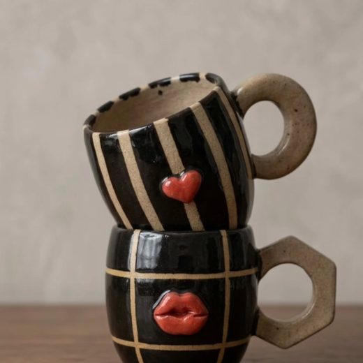 Canecas pretas com detalhes vermelhos